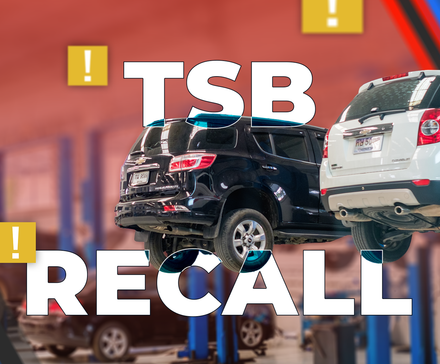 Два внедорожника на подъёмниках в автосервисе, текст 'TSB' над 'RECALL' и жёлтые значки предупреждения