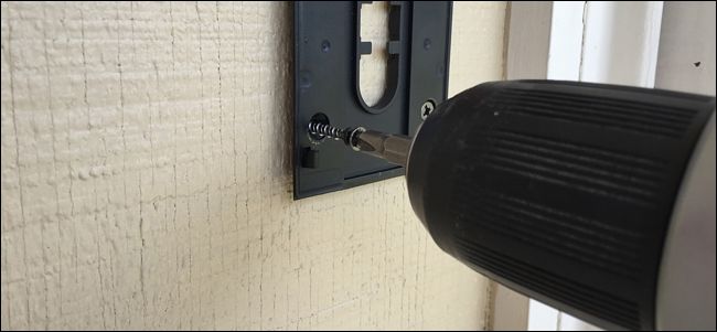 Крепление монтажной пластины к стене шурупами с помощью дрели