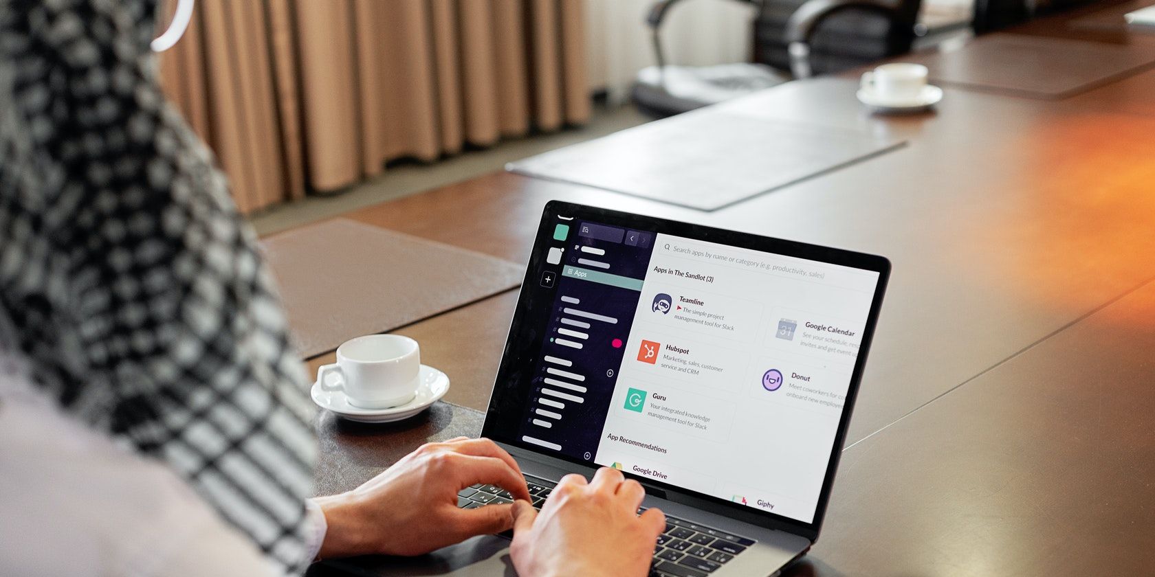 Image shows person using a laptop and Slack