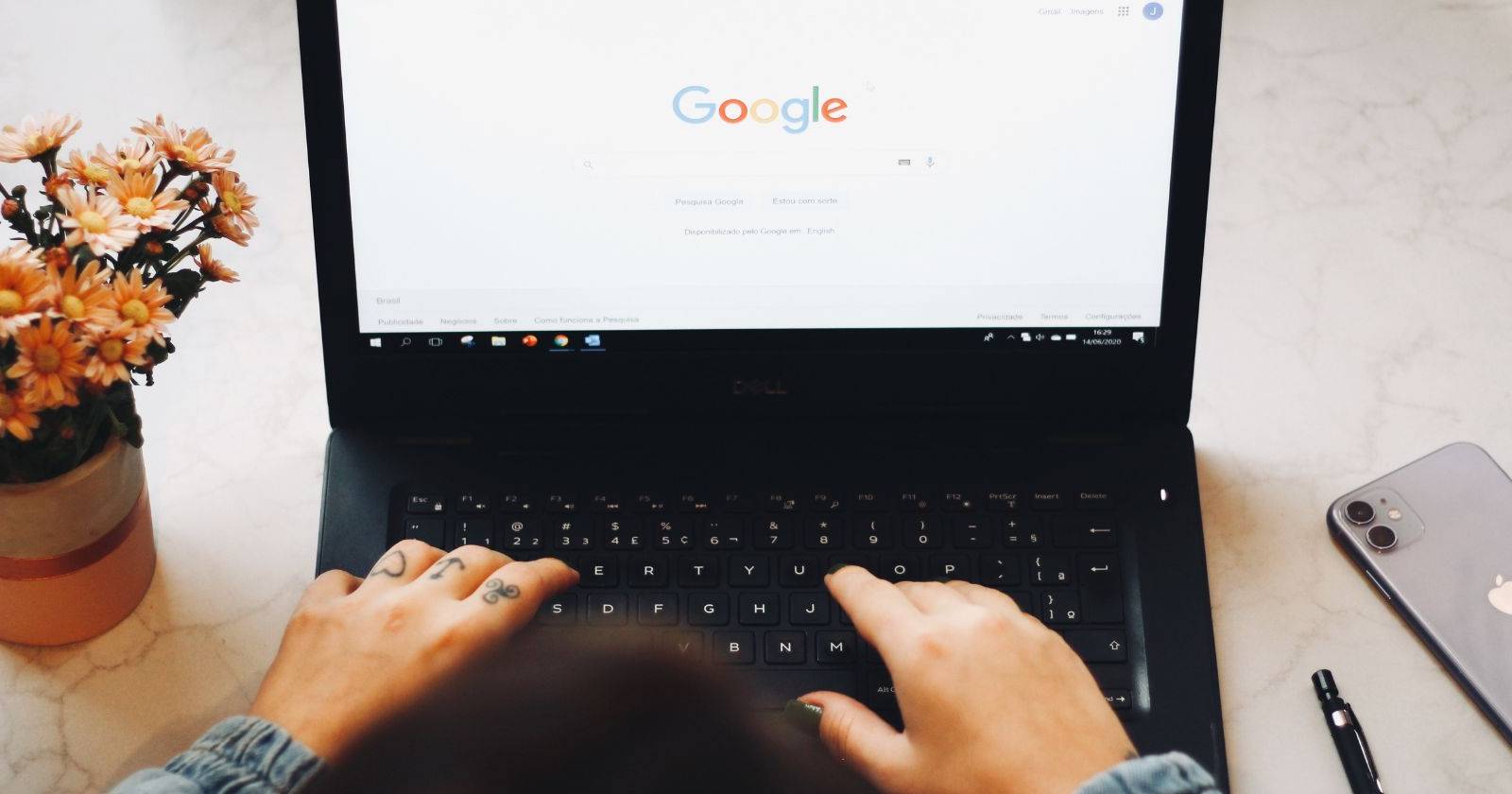 Вид сверху: человек использует поиск Google на ноутбуке