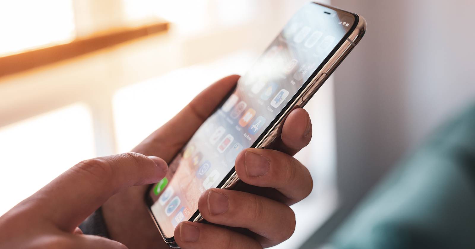 Мужчина прикасается к экрану iPhone