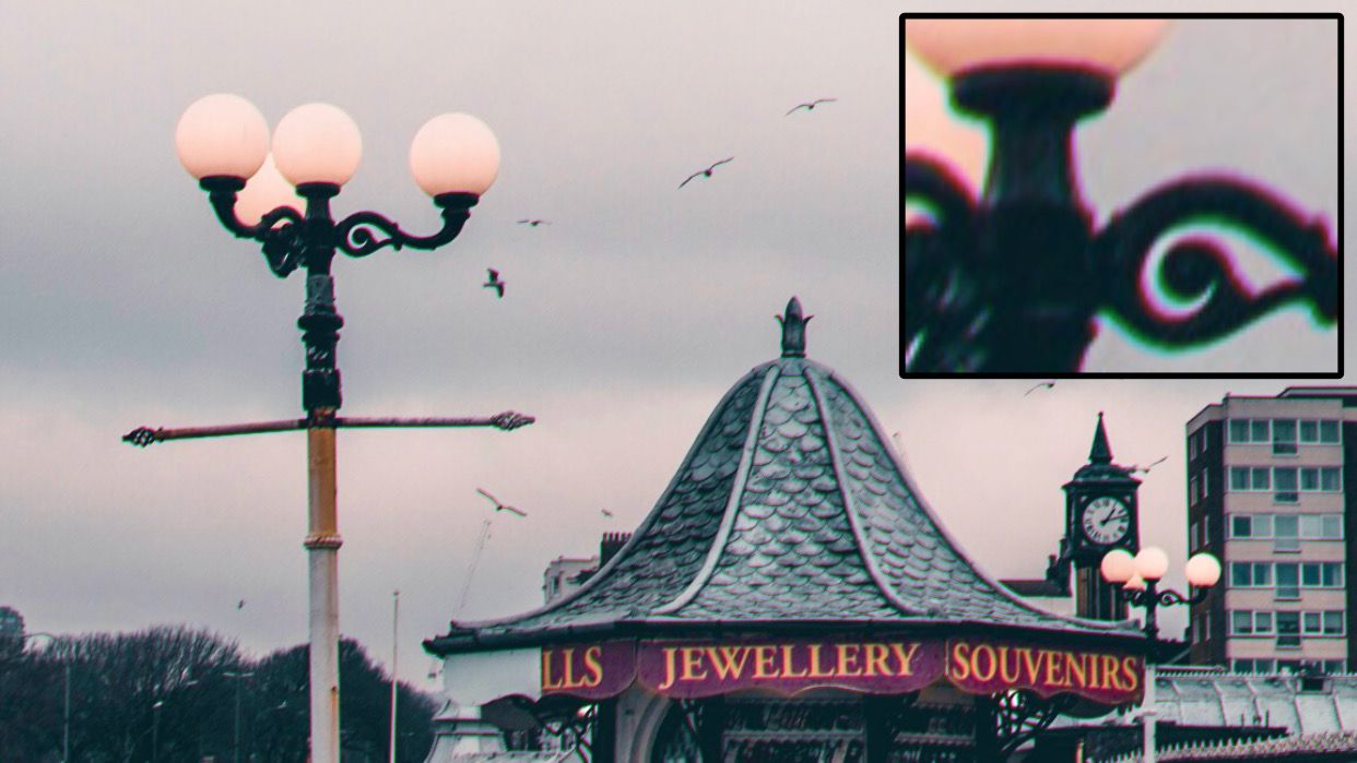 Трансверсная хроматическая аберрация у уличного фонаря и крыши магазина в пасмурный день