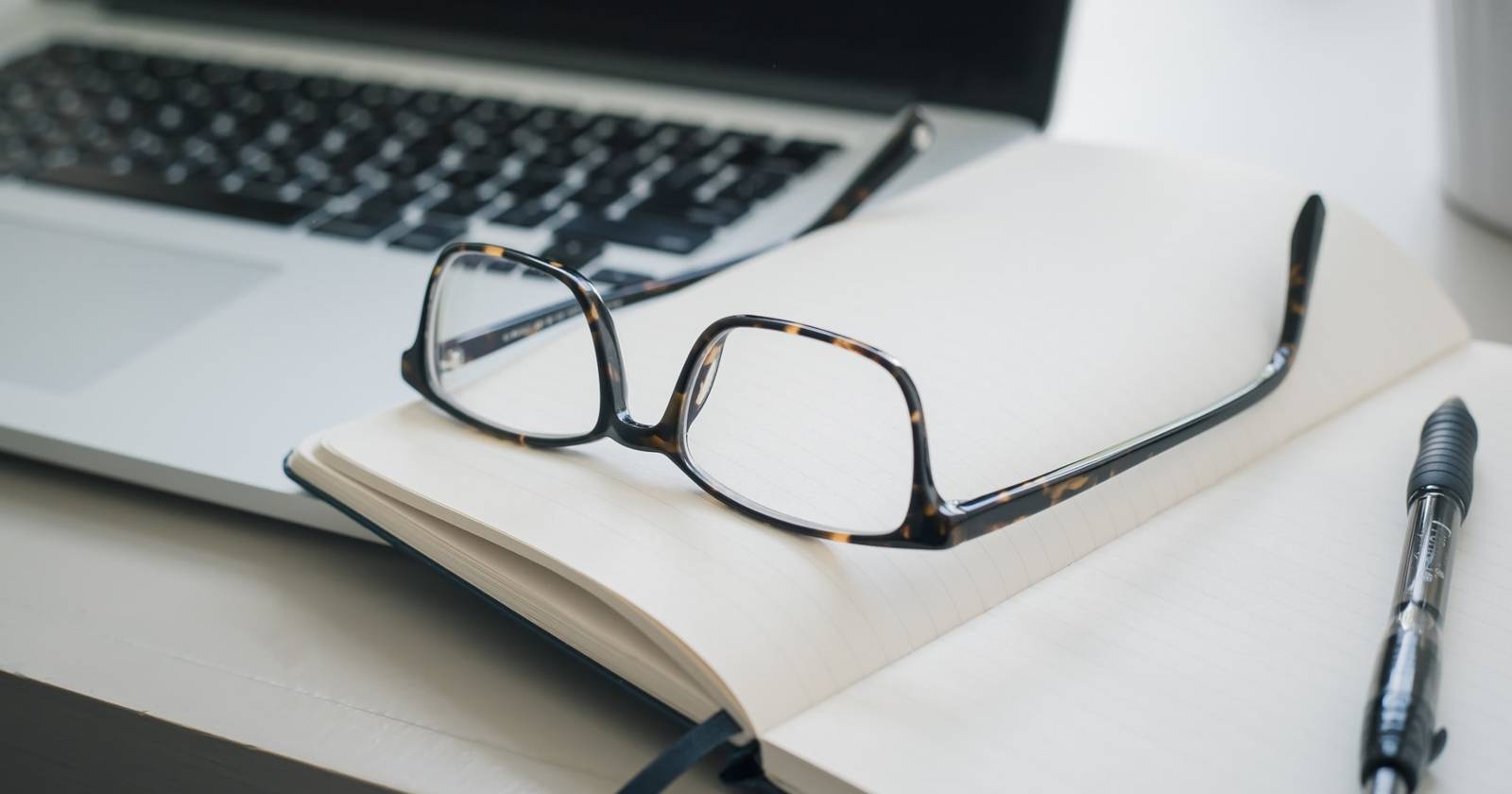 Читальные очки на ноутбуке и блокноте