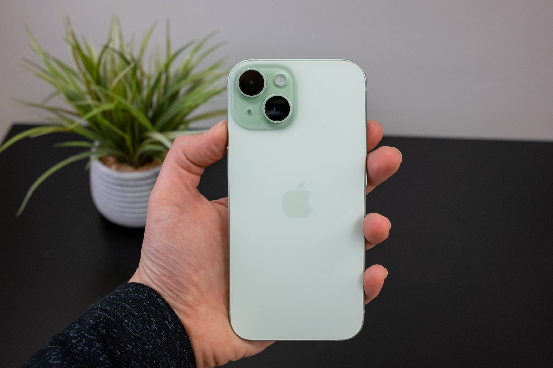 Человек держит iPhone 15.