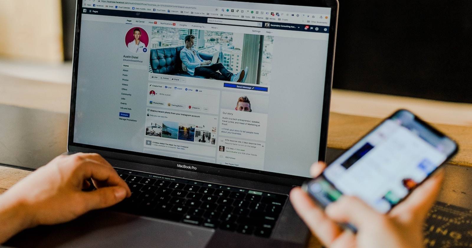 Человек, просматривающий профиль Facebook на ноутбуке и смартфоне одновременно