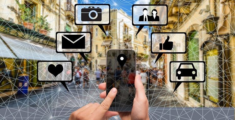 Палец указывает на смартфон с иконками разных способов связи