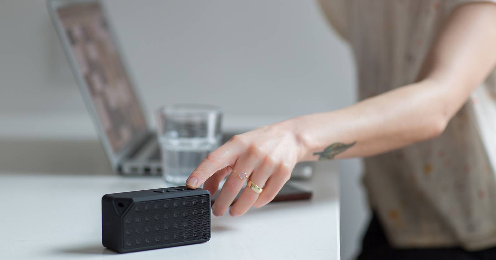 Человек включает Bluetooth-колонку.