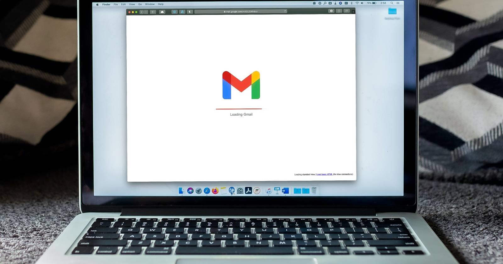 Компьютер на диване, на экране открыт браузер с Gmail