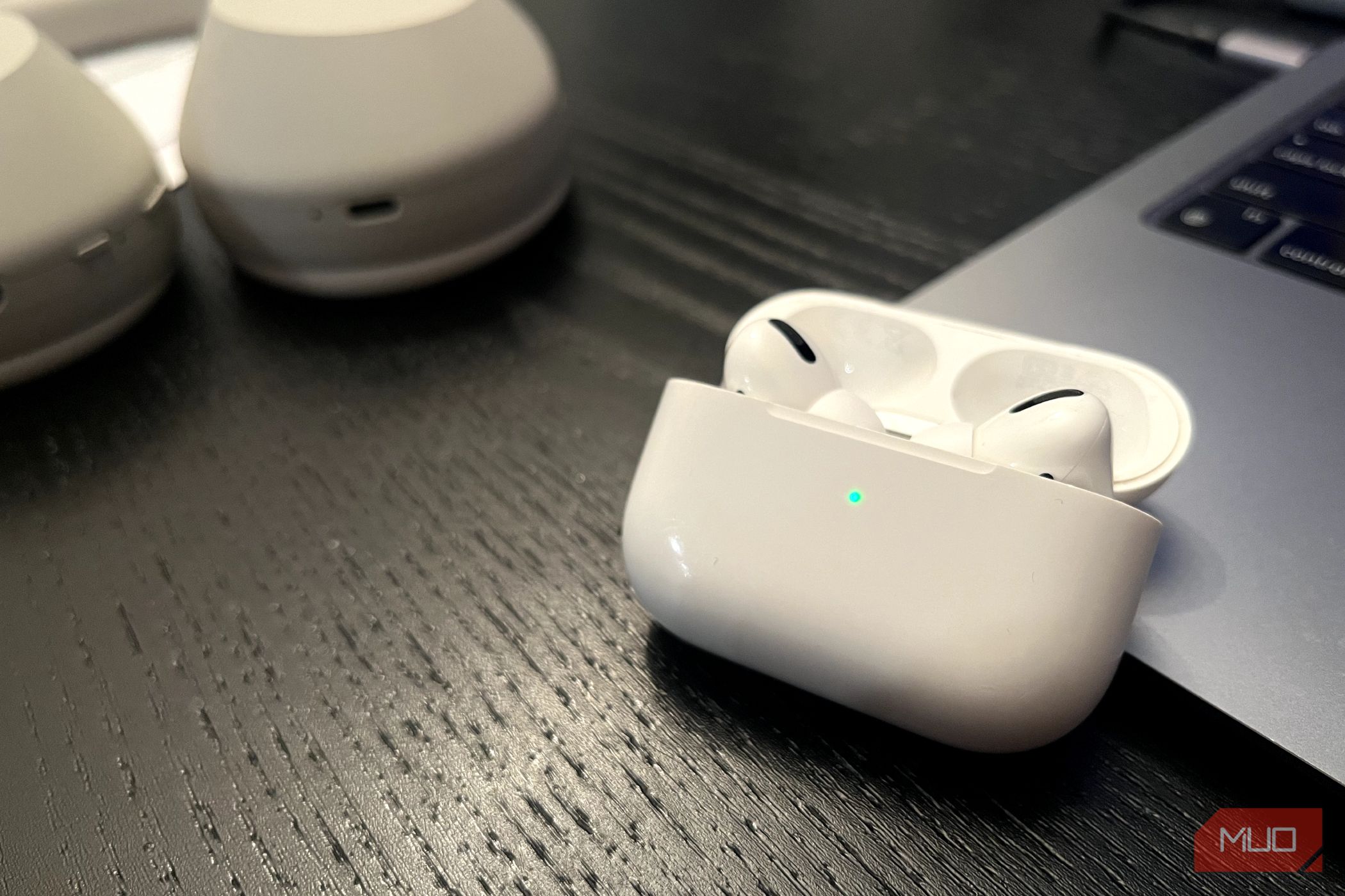 Чехол AirPods Pro открыт, зелёный индикатор статуса.