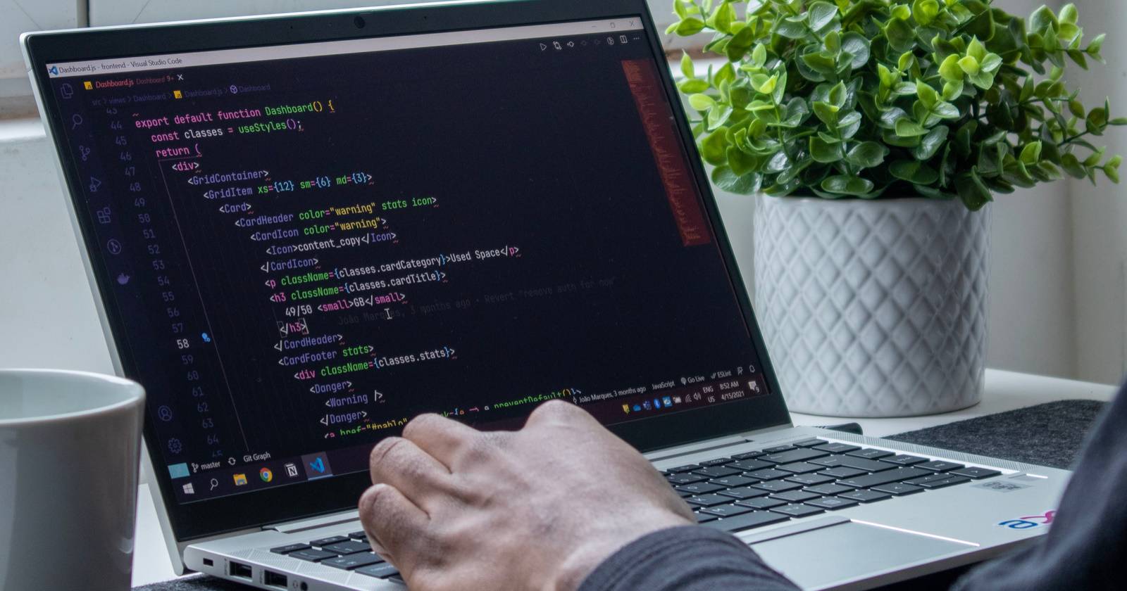 Portatile aperto che mostra una persona che digita codice in un editor di testo