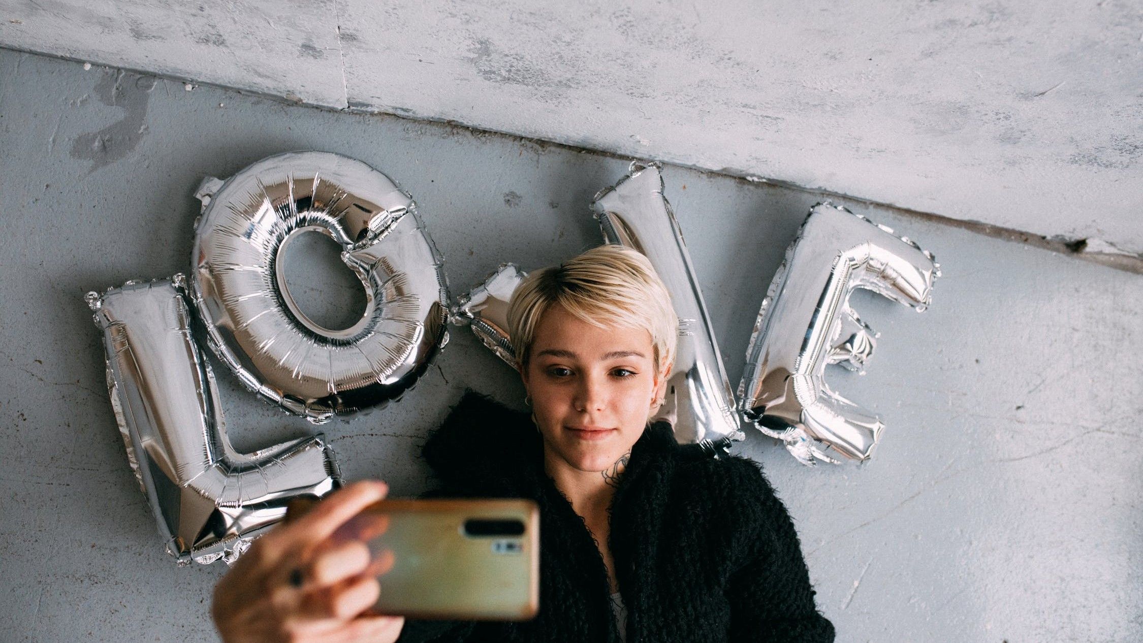 Женщина делает селфи на фоне шаров