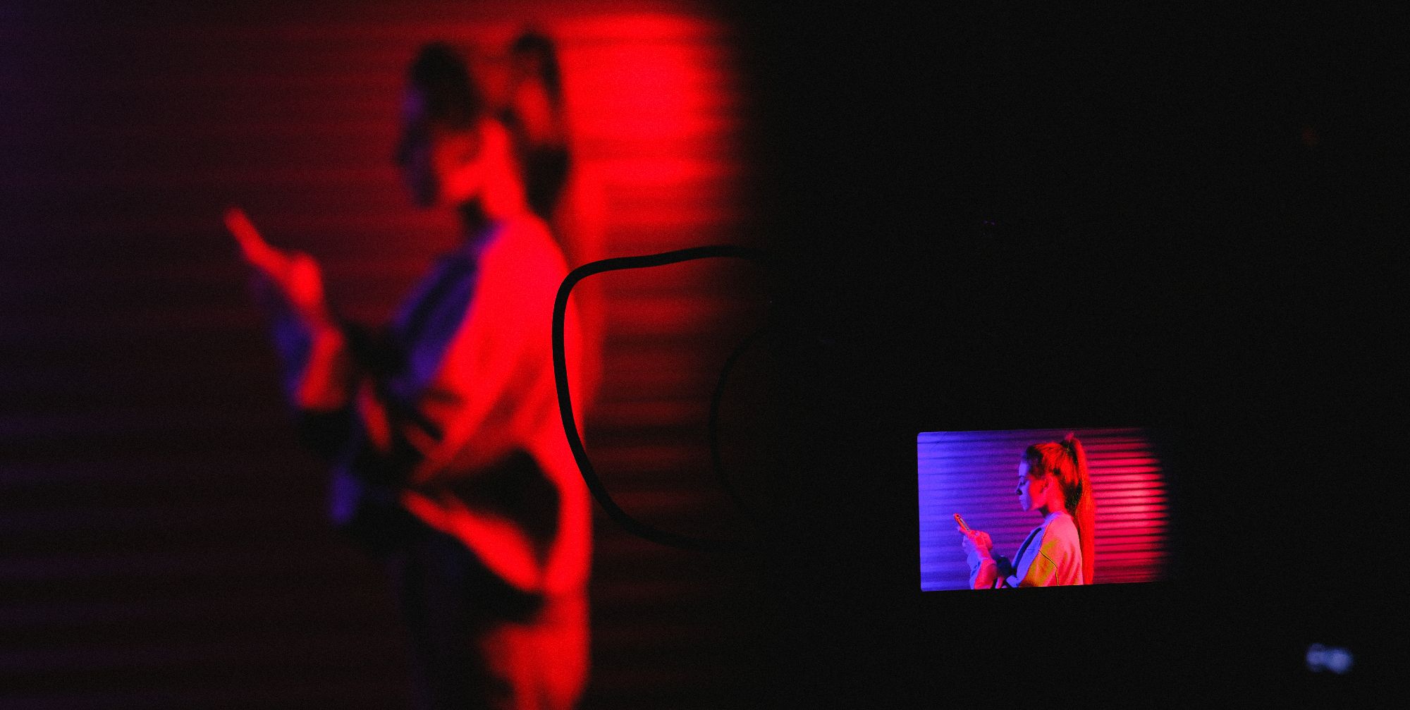 женщина стоит за камерой с видоискателем