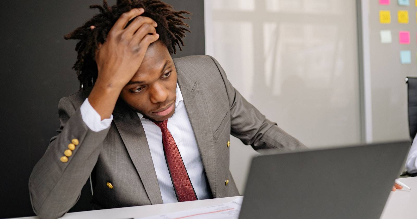 мужчина сидит обеспокоенный рядом с ноутбуком