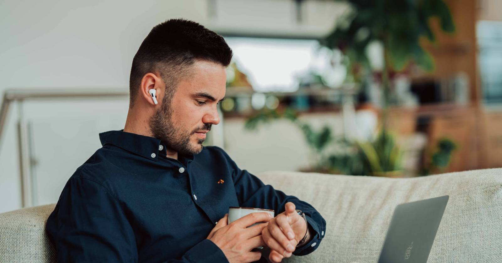 Мужчина в беспроводных наушниках AirPods, принимающий звонок.