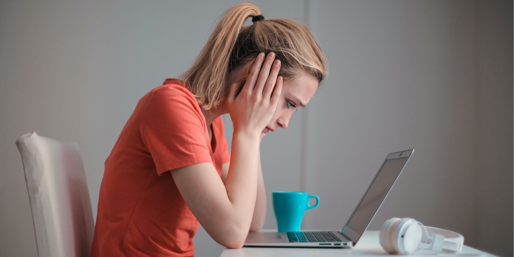 задумчивая женщина смотрит на экран ноутбука