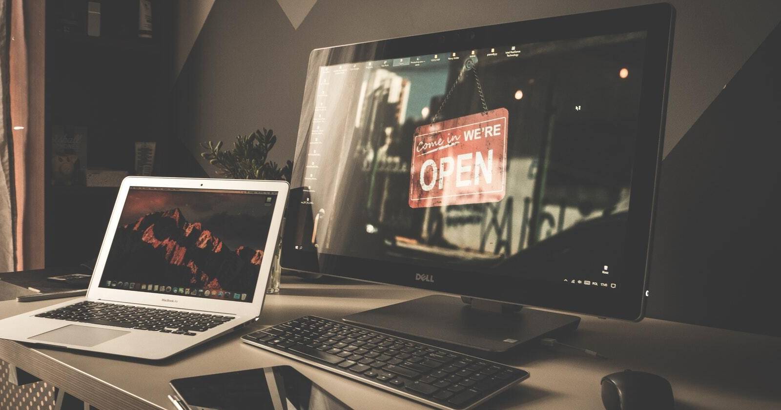 Ein MacBook und ein Dell AIO mit angeschlossenen Peripheriegeräten