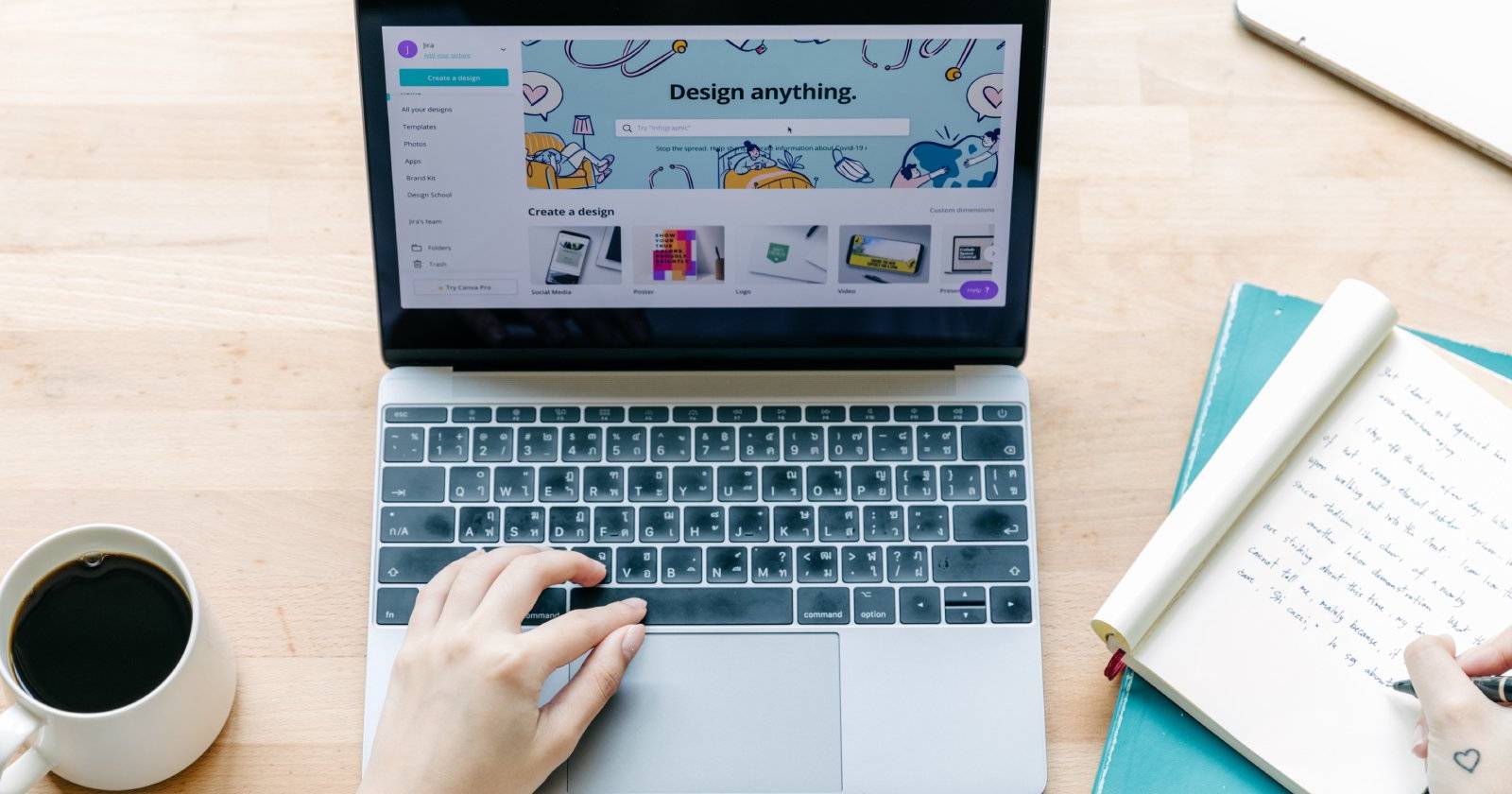 Canva open on laptop with notebook and coffee on table
