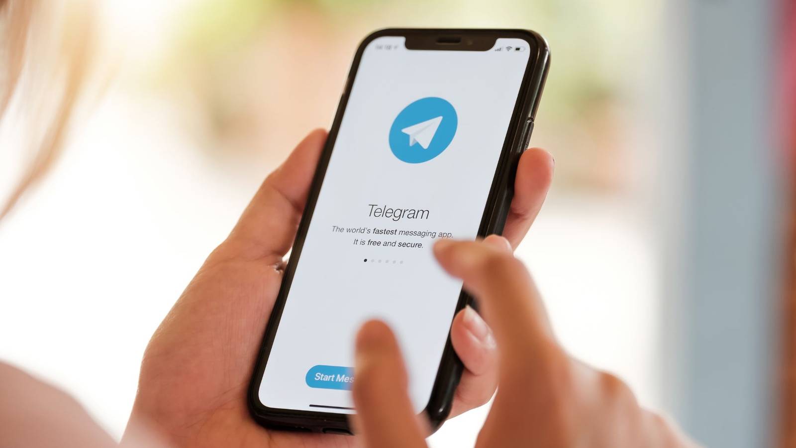 Человек использует приложение Telegram на смартфоне