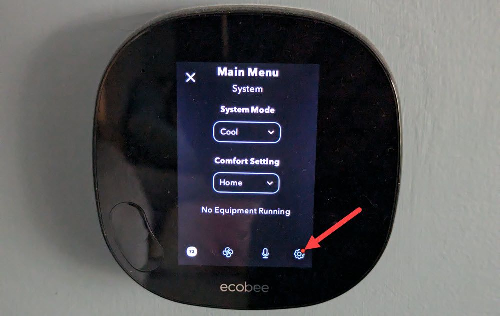 Значок меню в нижнем левом углу экрана термостата.