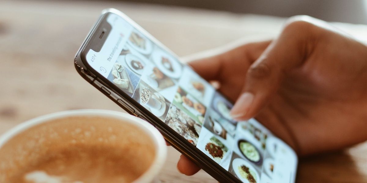 фотография человека листающего смартфон с соцсетями