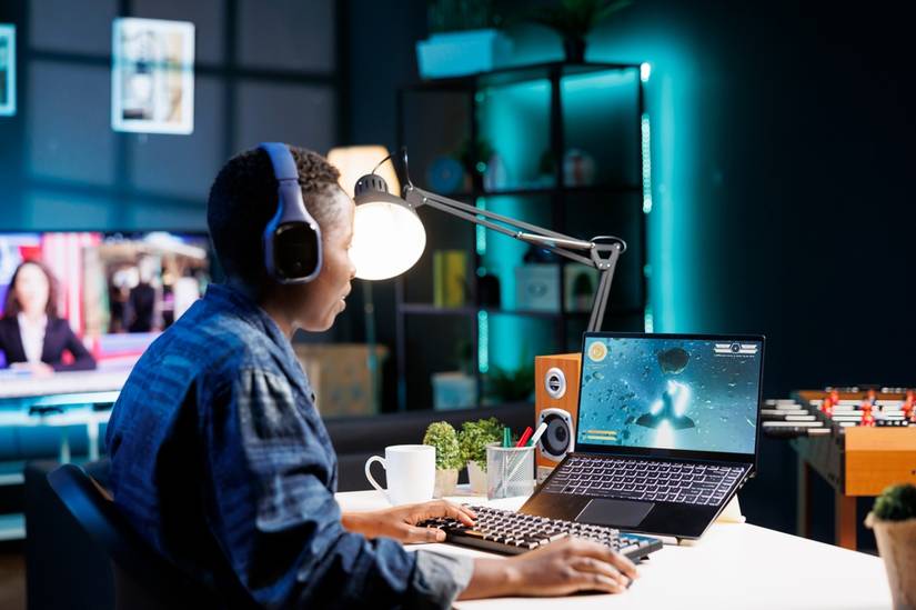 Женщина играет в видеоигру на ноутбуке.