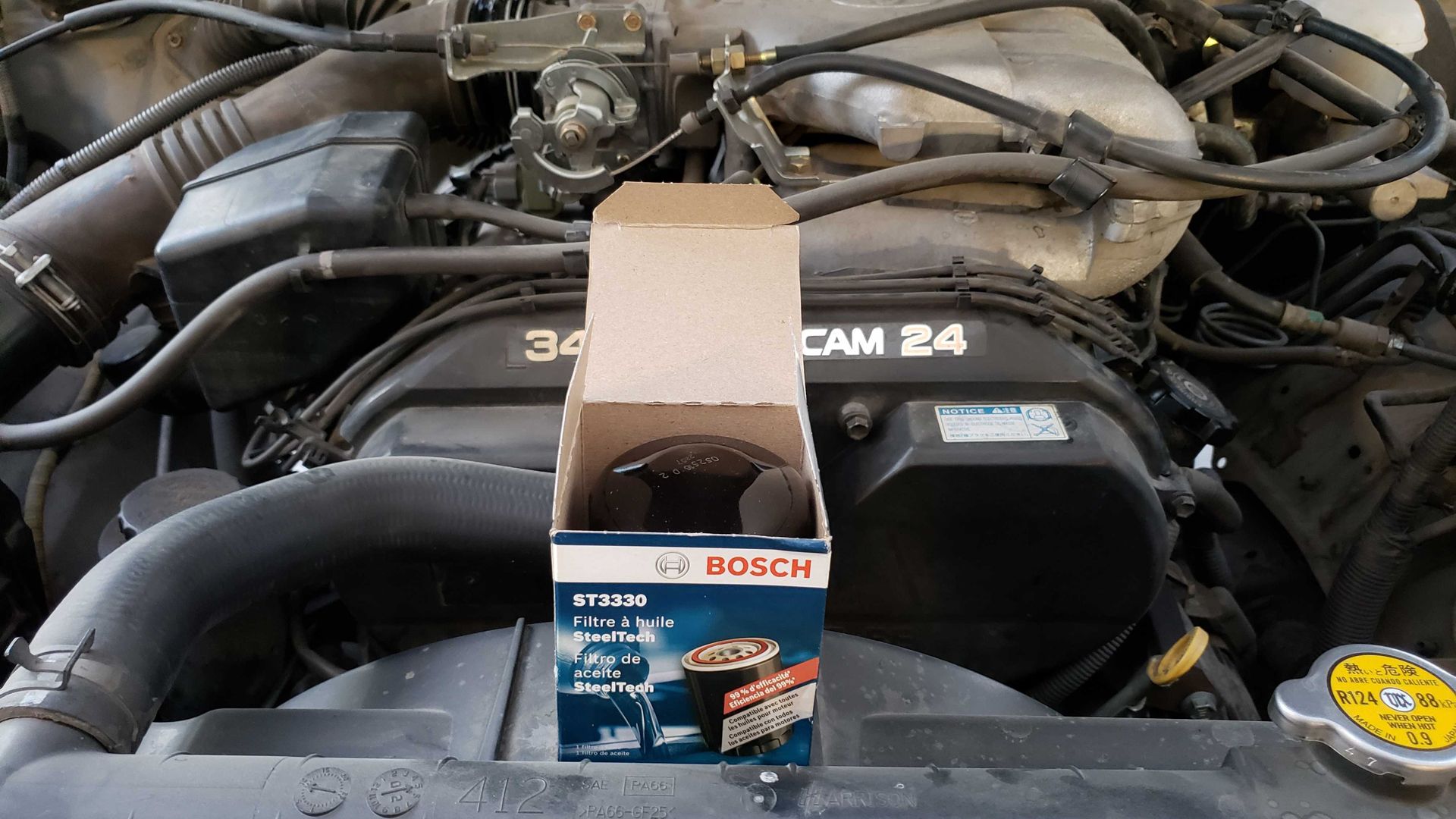 Масляный фильтр на фоне двигателя автомобиля