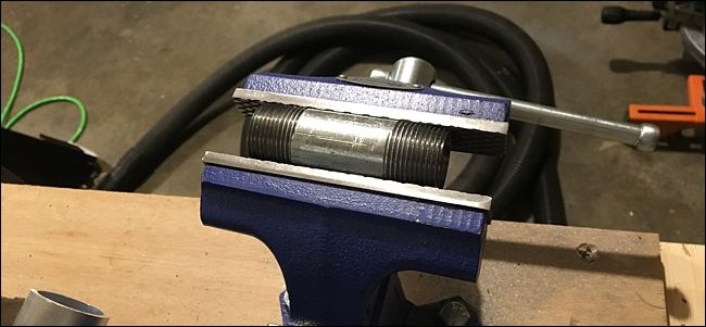 Труба зажата в тисках для сверления