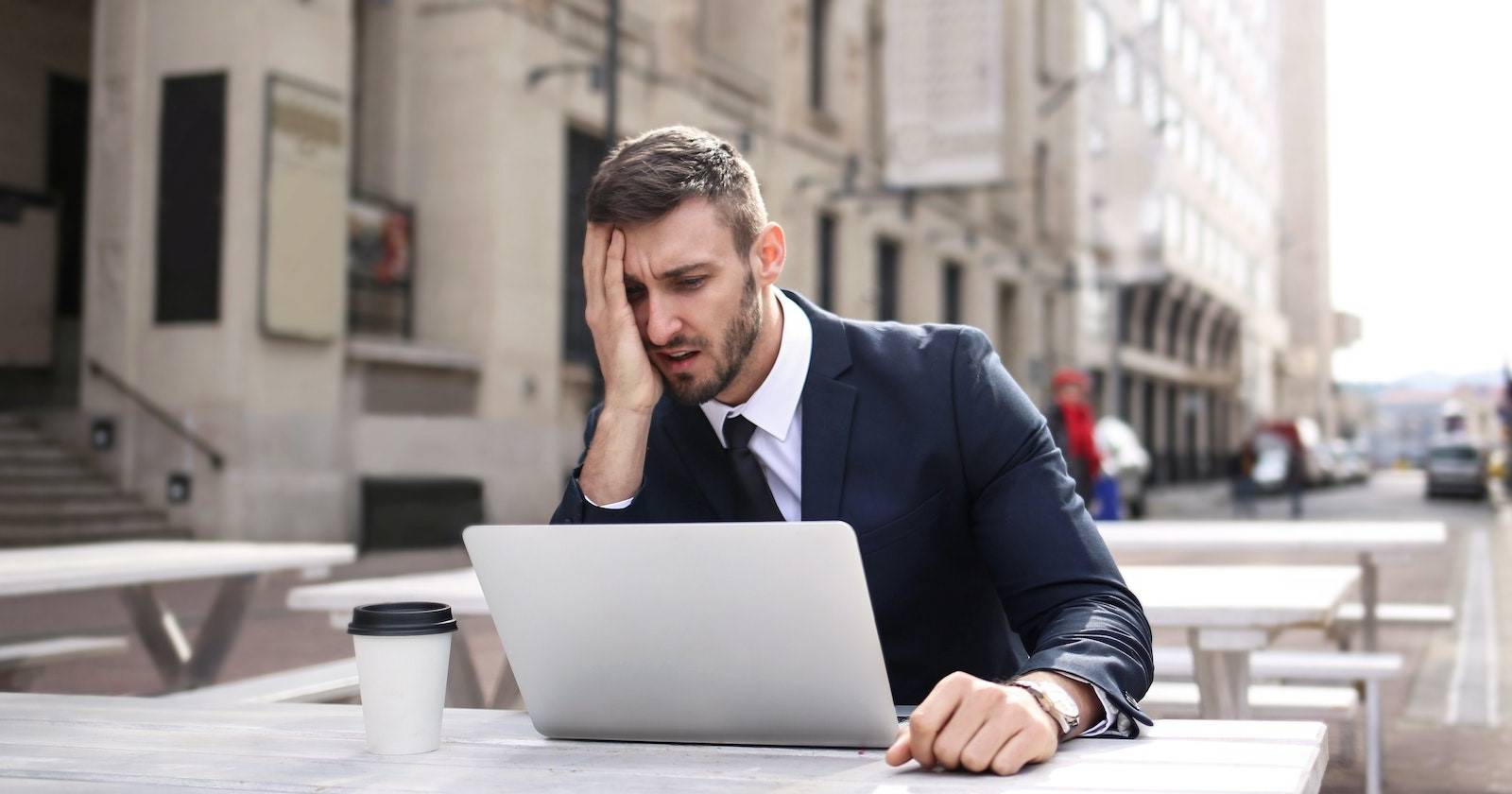 Человек раздражён, видя уведомление на ноутбуке