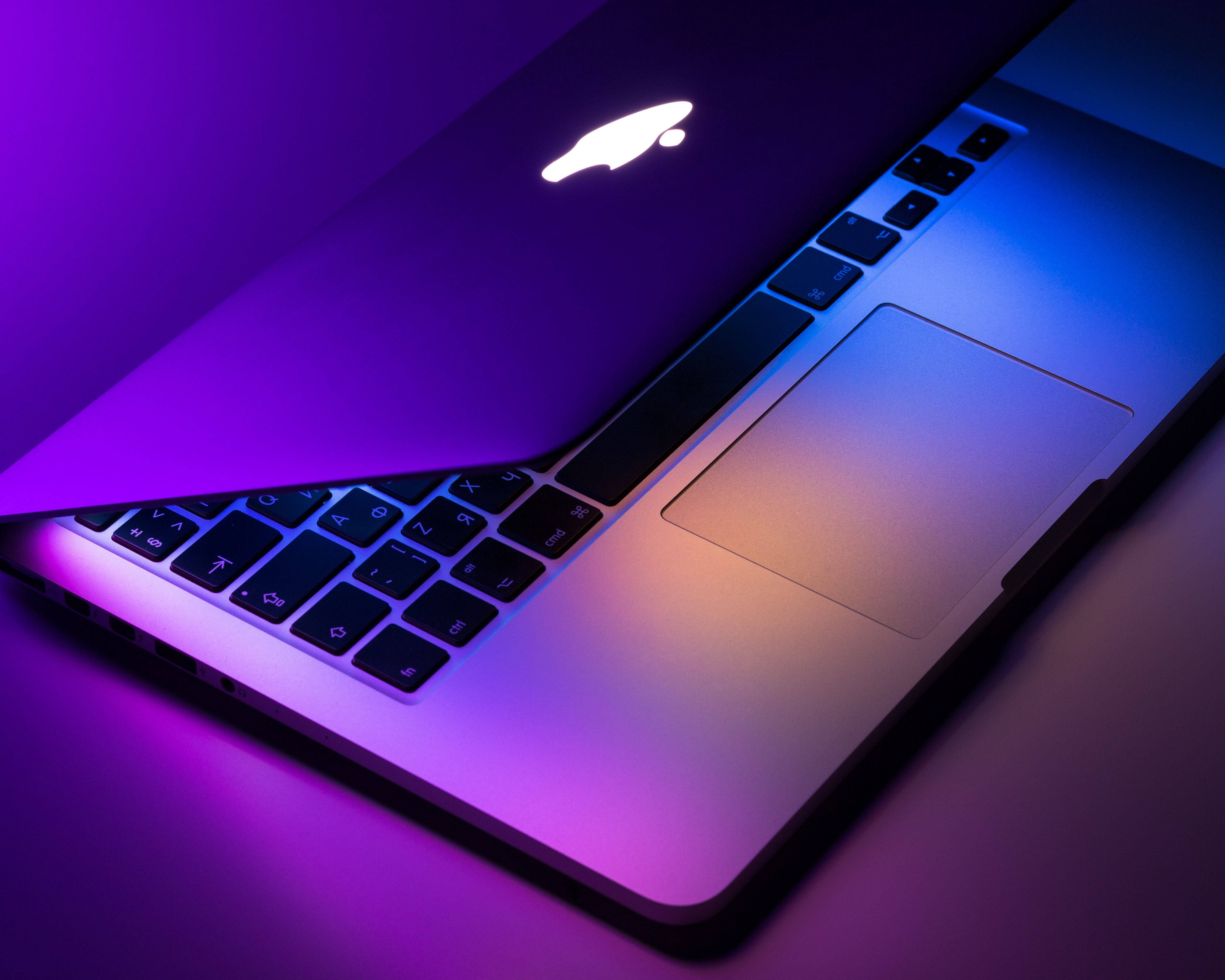 MacBook Pro с полуприкрытой крышкой, показывающий пространство между клавиатурой и экраном