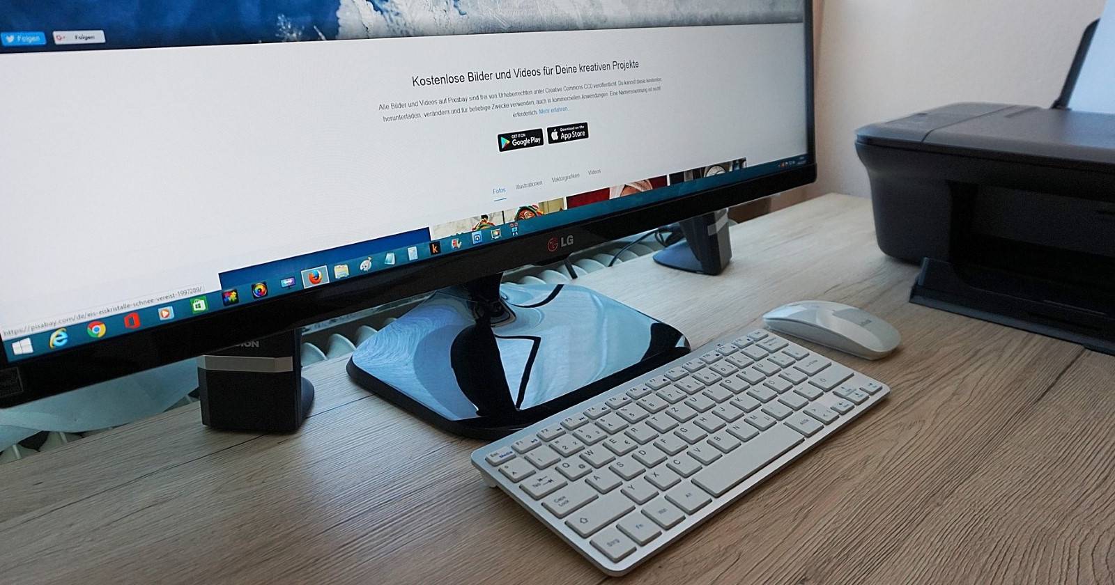 Монитор на деревянном столе рядом с принтером