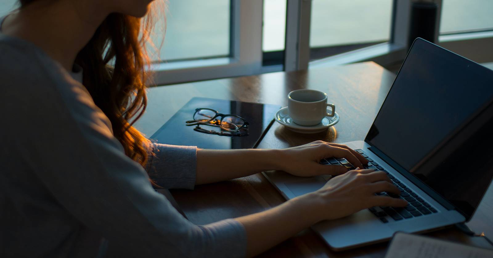 Женщина работает за ноутбуком дома.