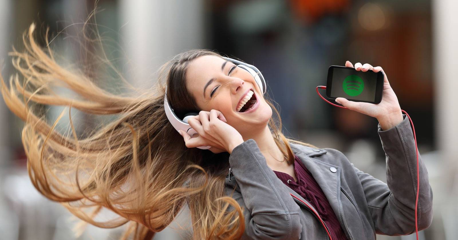 Крупный портрет наушников и интерфейса Spotify