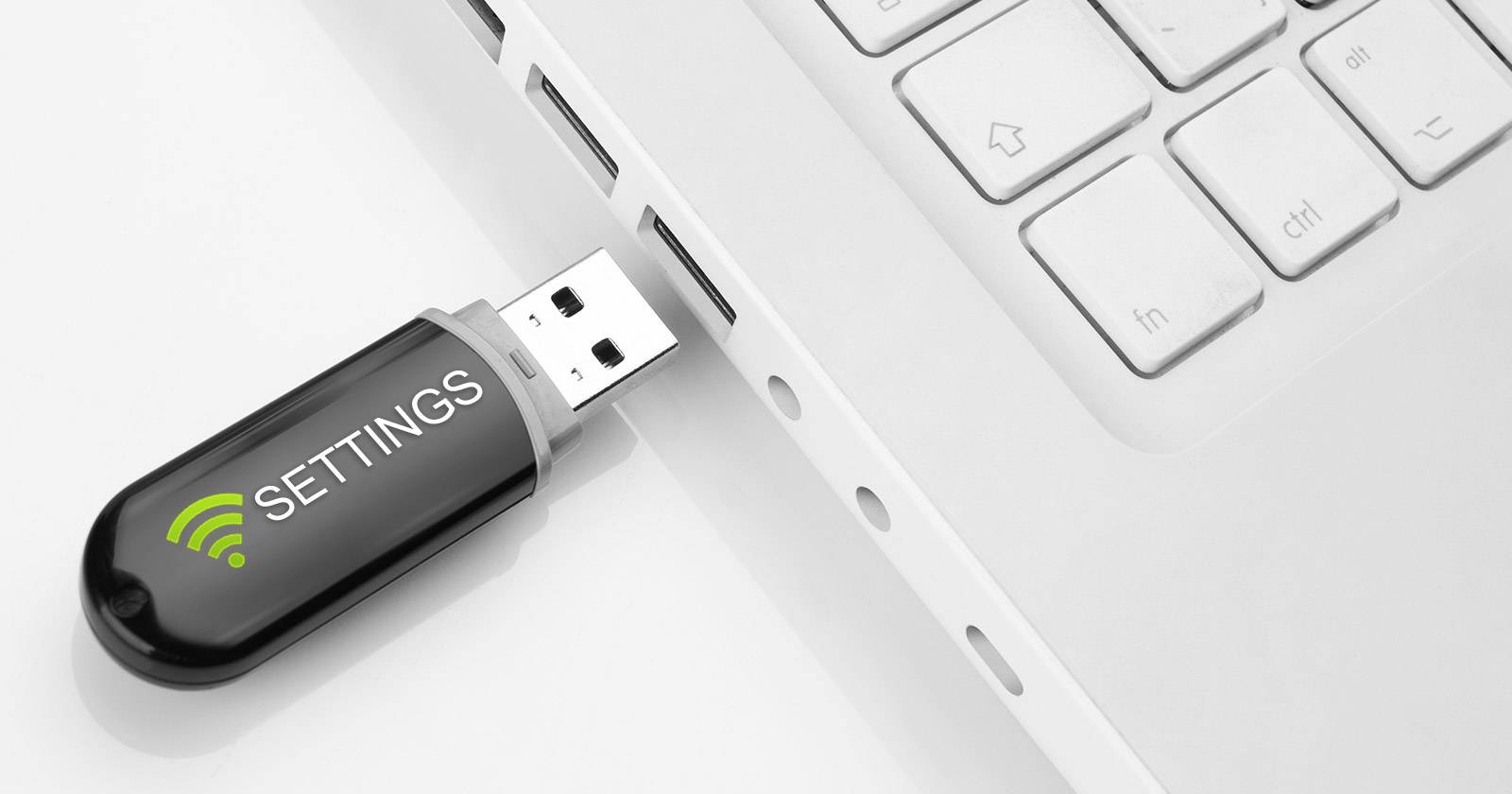 USB-накопитель и ноутбук с открытыми настройками Wi‑Fi
