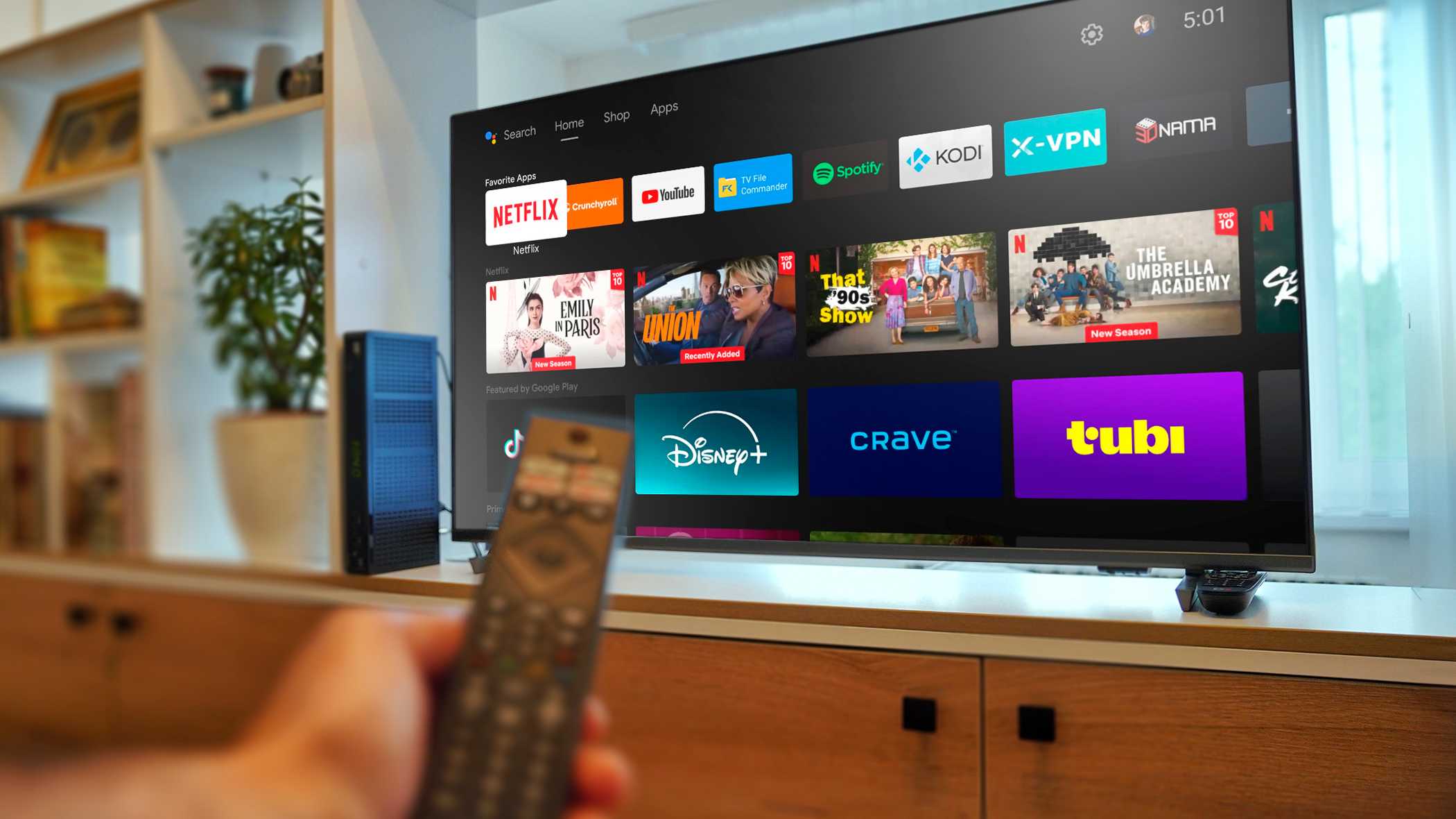 Смарт‑телевизор на Android и рука с пультом дистанционного управления.