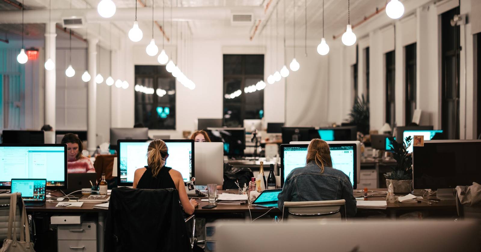 Группа людей за компьютерами в офисе, выполняющих удалённый доступ