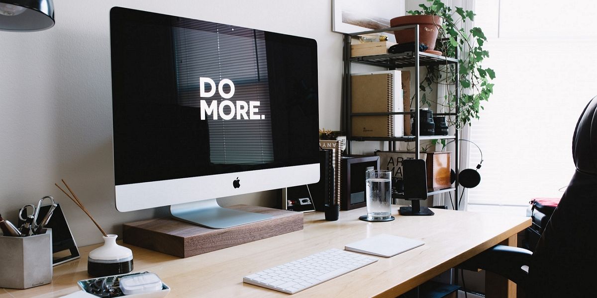 Серебристый iMac с клавиатурой и трекпадом в комнате