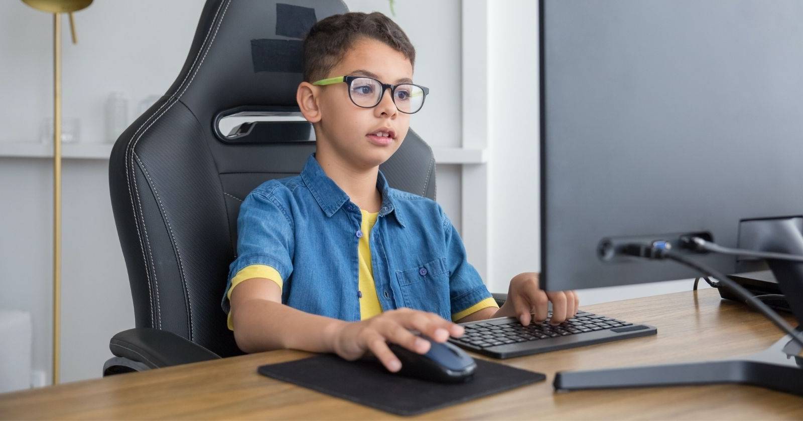 Ребёнок за компьютером, смотрит игровое видео на YouTube и улыбается