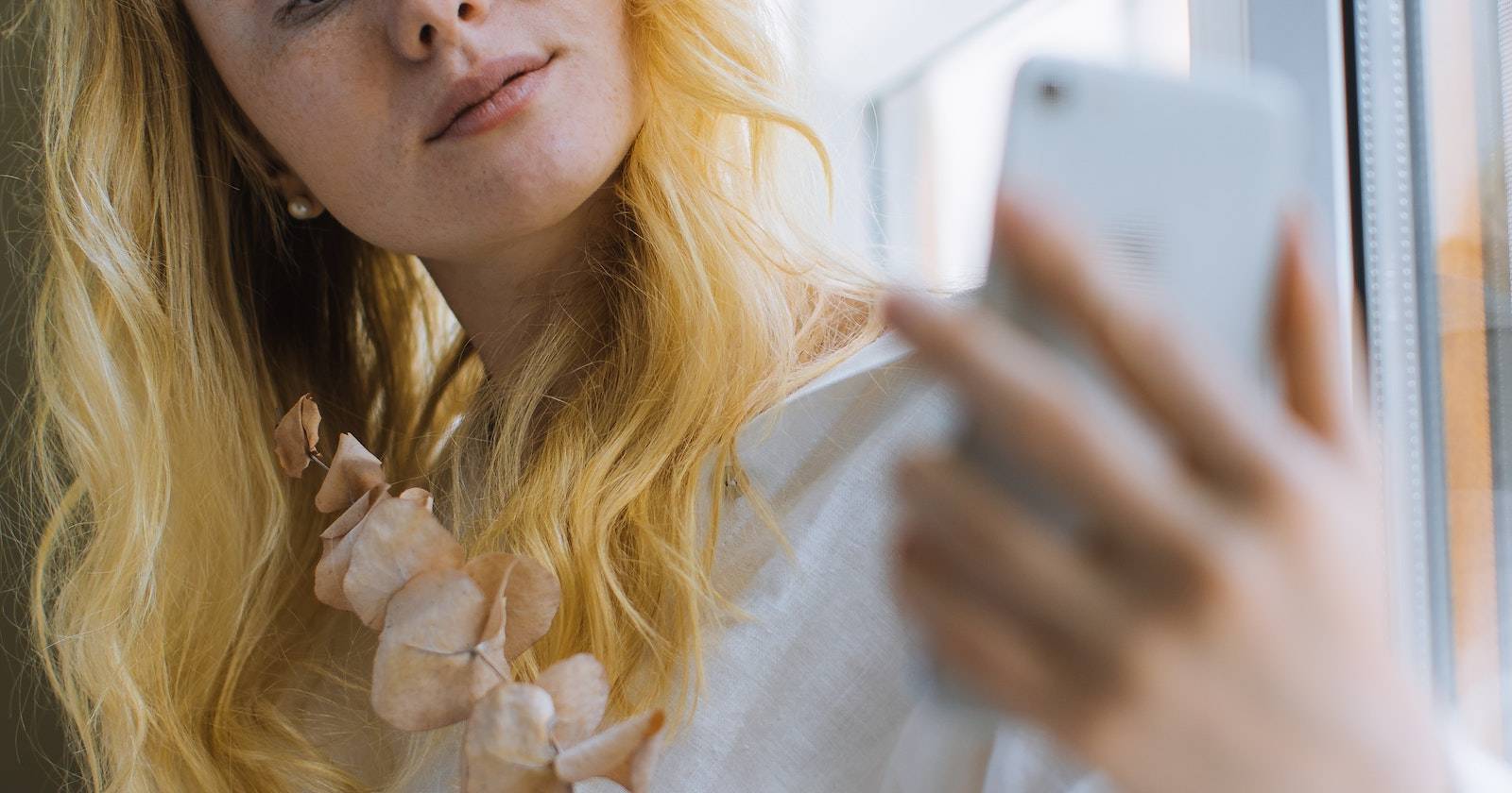 женщина делает селфи с букетом