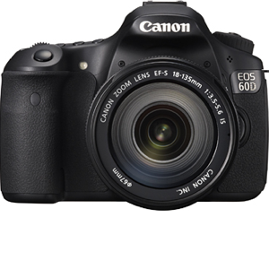 Крупный план цифровой зеркальной камеры Canon рядом с компьютером