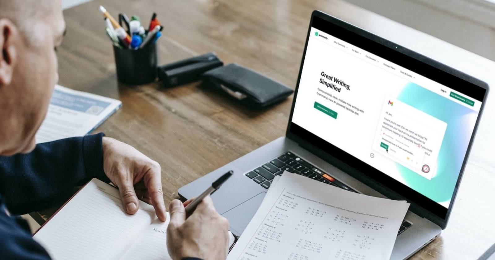 Человек работает за ноутбуком с открытой домашней страницей Grammarly