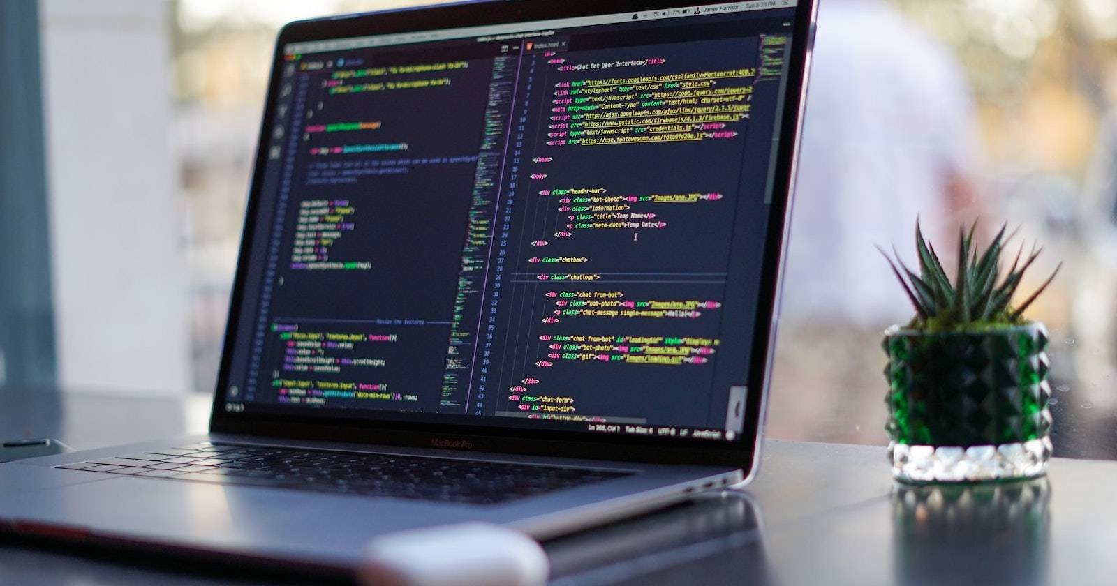 Ноутбук на рабочем столе с редактором кода в тёмной теме.