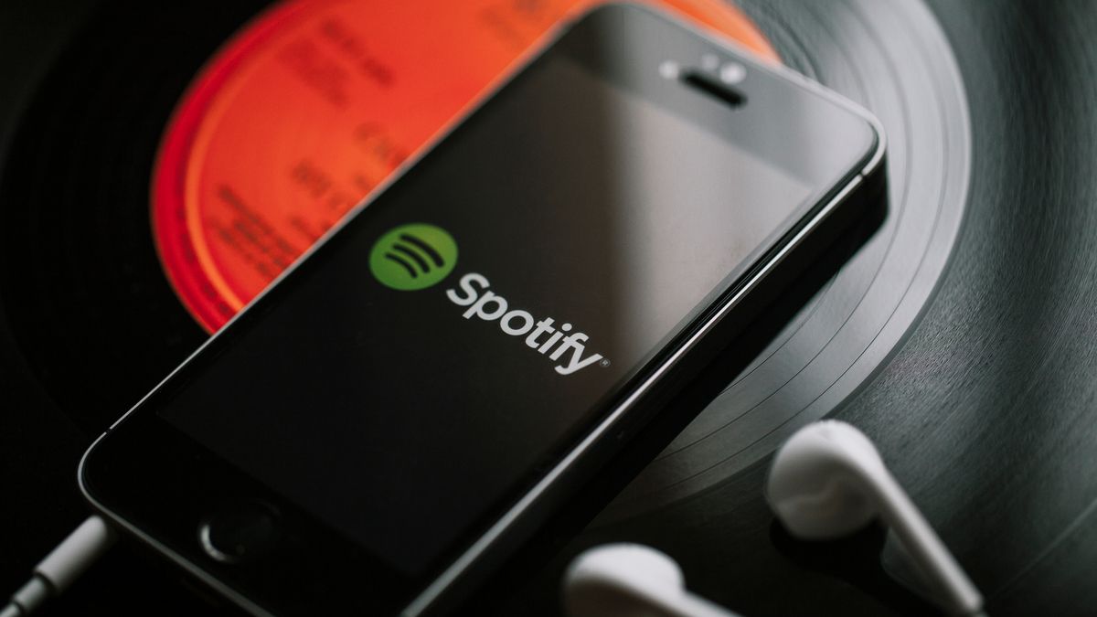 Логотип Spotify на смартфоне на виниловой пластинке