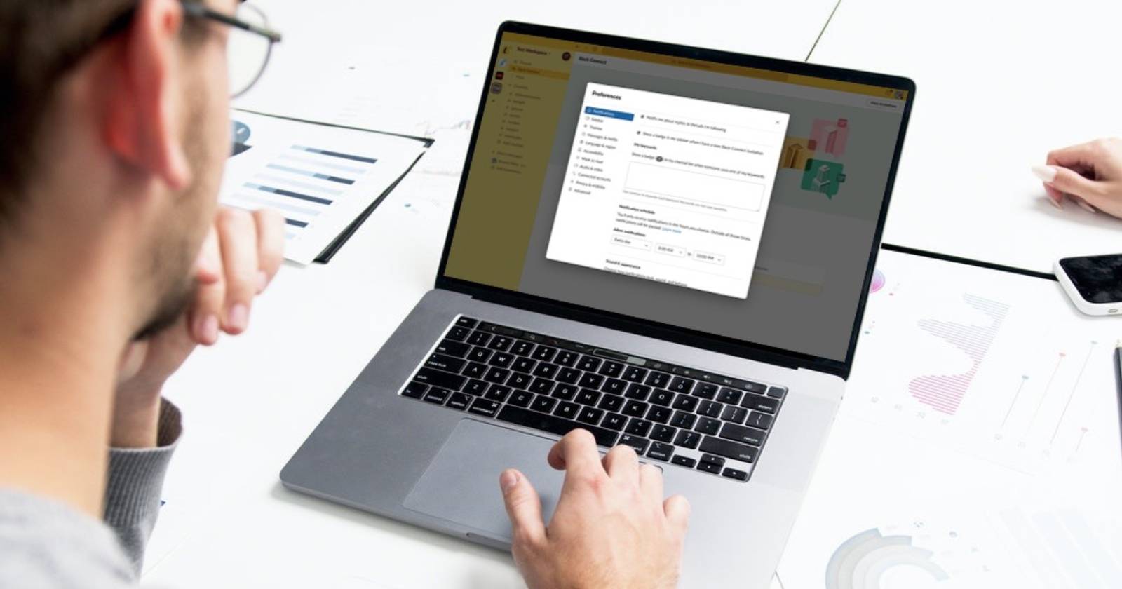 Мужчина смотрит на ноутбук с открытыми настройками Slack