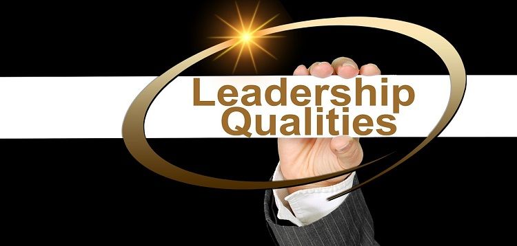 Рука держит карточку с надписью «Лидерские качества»