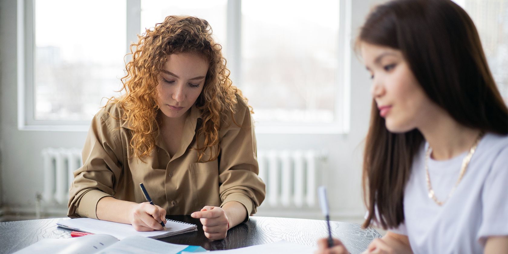 Два студента пишут эссе во время занятия
