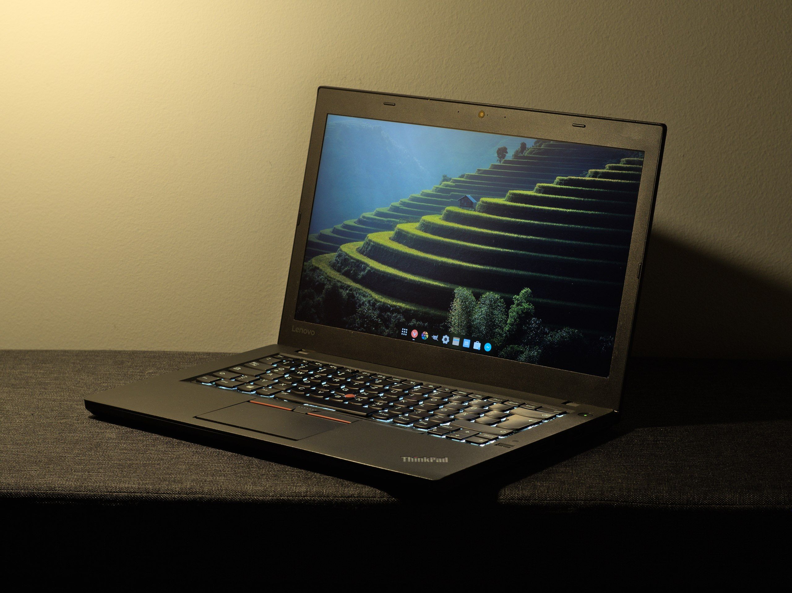 Lenovo ThinkPad T460 laptop 45˚ picture with the keyboard backlight turned on. The computer is running the GNOME desktop.