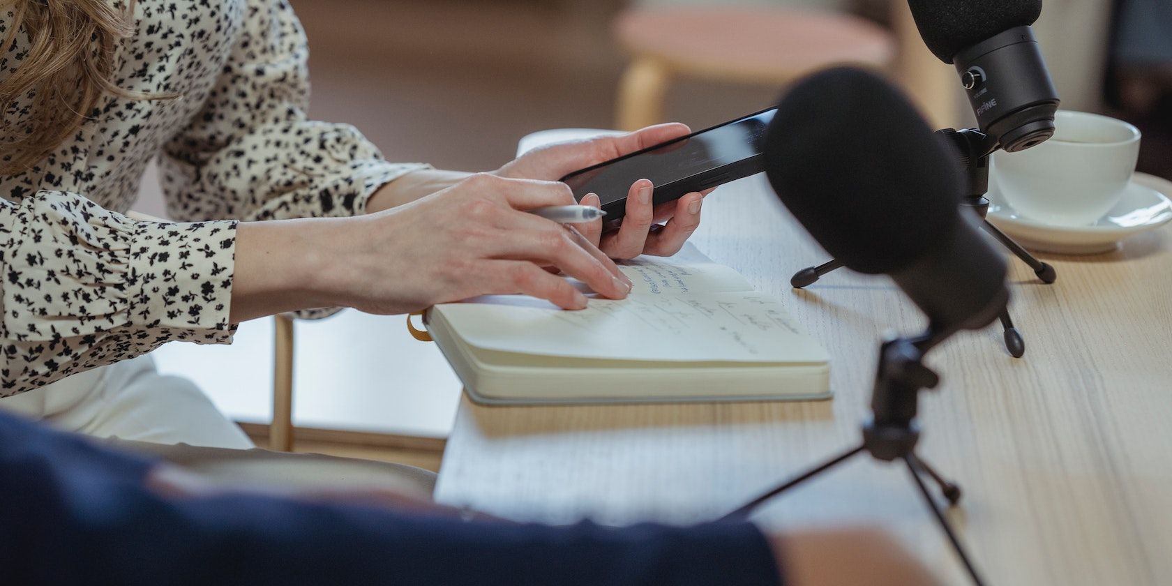 женщина использует телефон на столе с микрофонами
