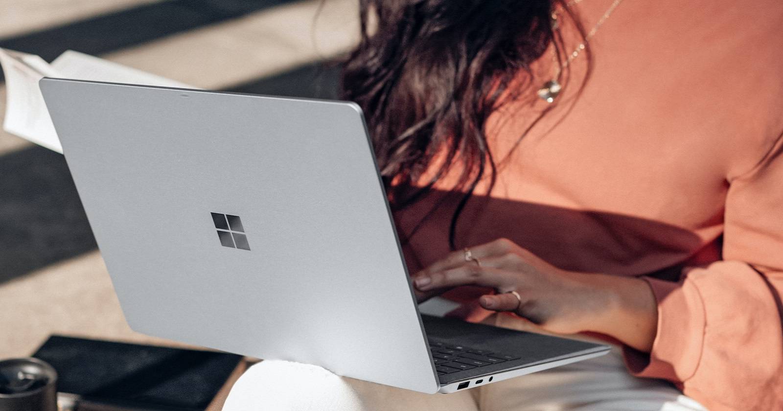 Человек использует устройство на Windows, размещая его на коленях