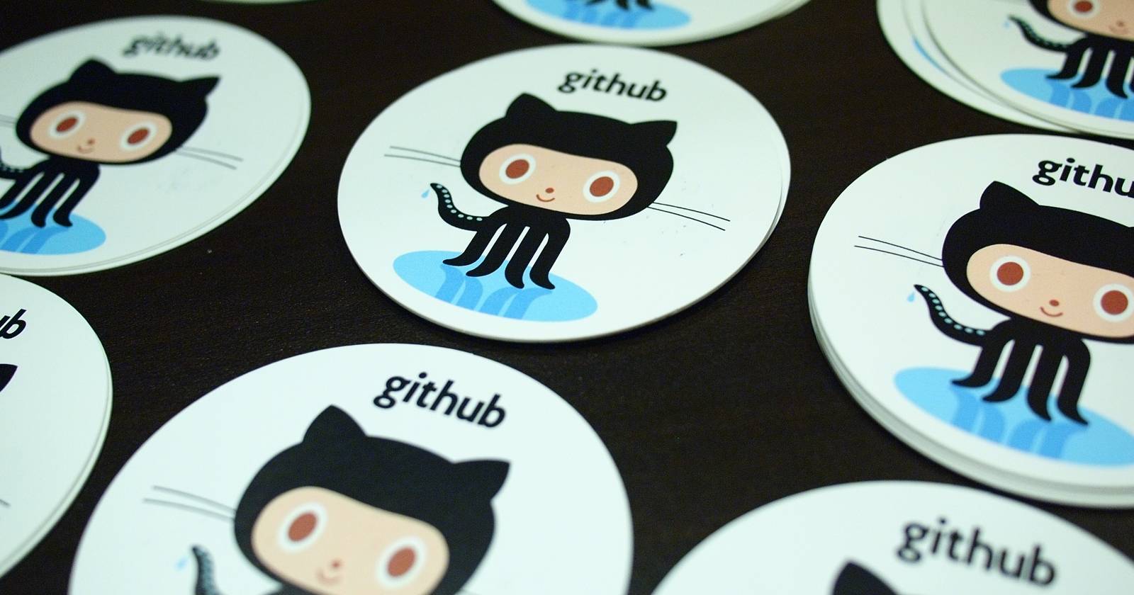 наклейки Octocat GitHub, рассыпанные по столу