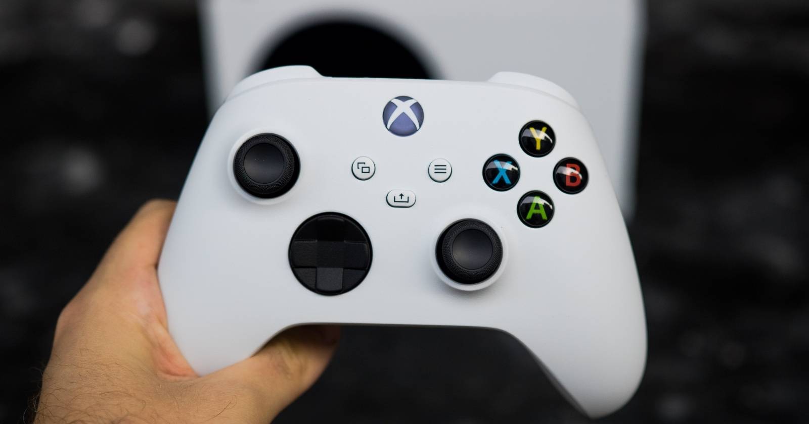 Фото геймпада Xbox Series S, удерживаемого над консолью Xbox Series S